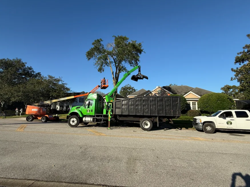 Crew operating grapple truck to load logs and tree debris