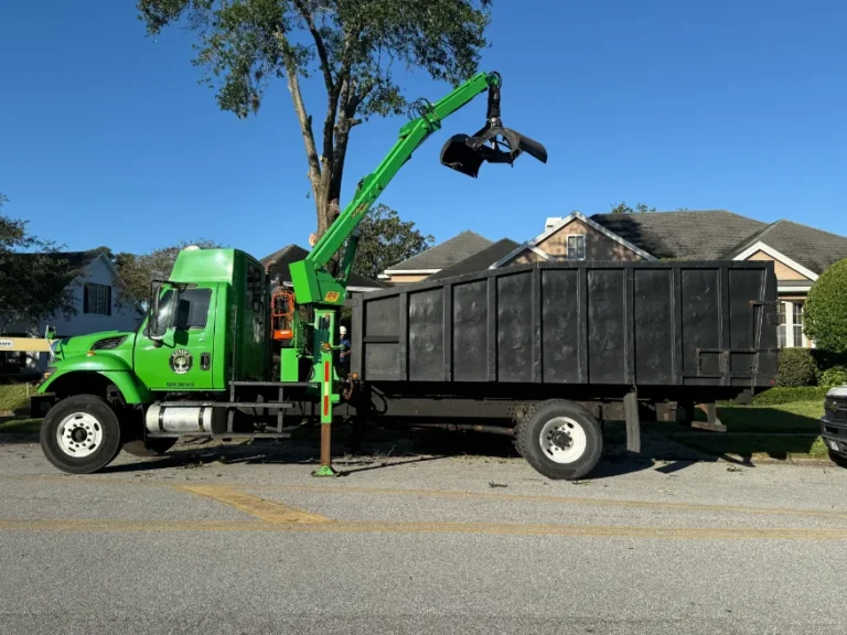 Kevin’s Tree Service green grapple truck parked in front of a home on a tree job