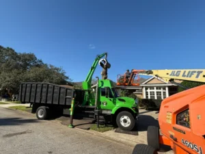 Green grapple truck and lift on a removal job