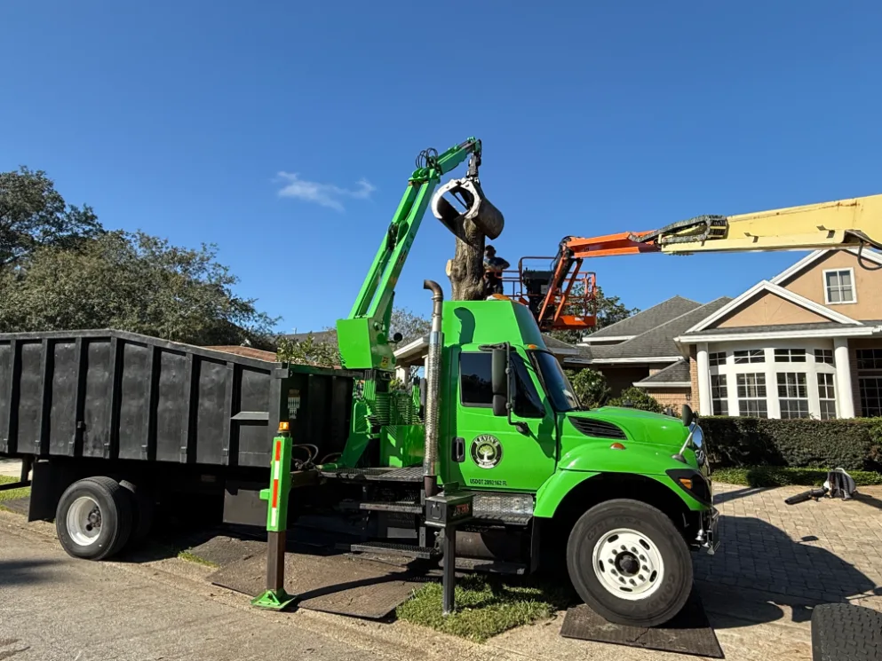 Storm cleanup with grapple truck hauling brush piles in Central Florida