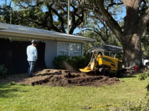 KTS stump grinder working on a large stump in a residential yard