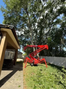 Spider lift working in a side yard next to a home